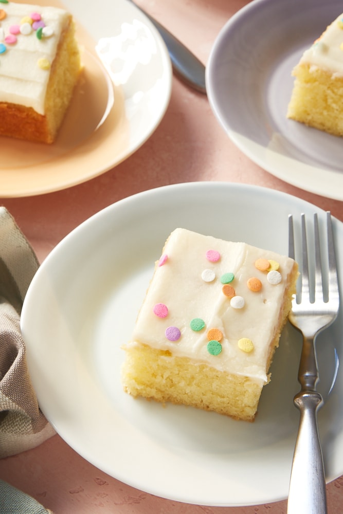 Pieces of Vanilla Cake on colorful plates, topped with sprinkles