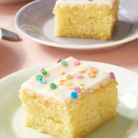 slice of Vanilla Cake on a green and white plate, topped with sprinkles