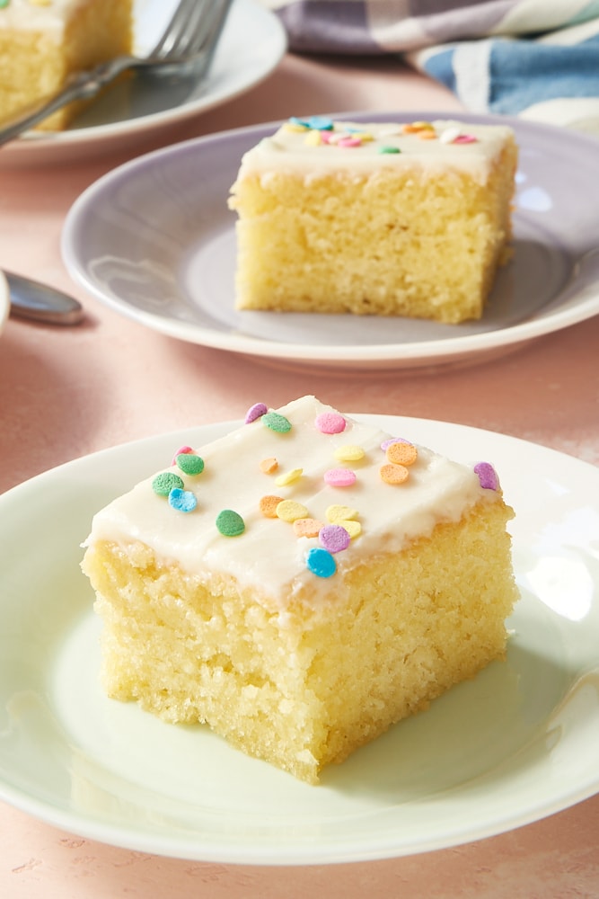slice of Vanilla Cake on a green and white plate, topped with sprinkles