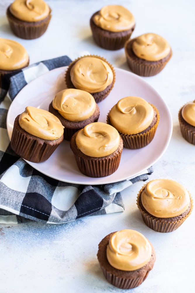 Mexican chocolate cupcakes on plate with additional cupcakes on tabletop