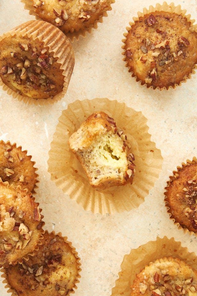 overhead view of Banana Cream Cheese Muffins on a beige surface