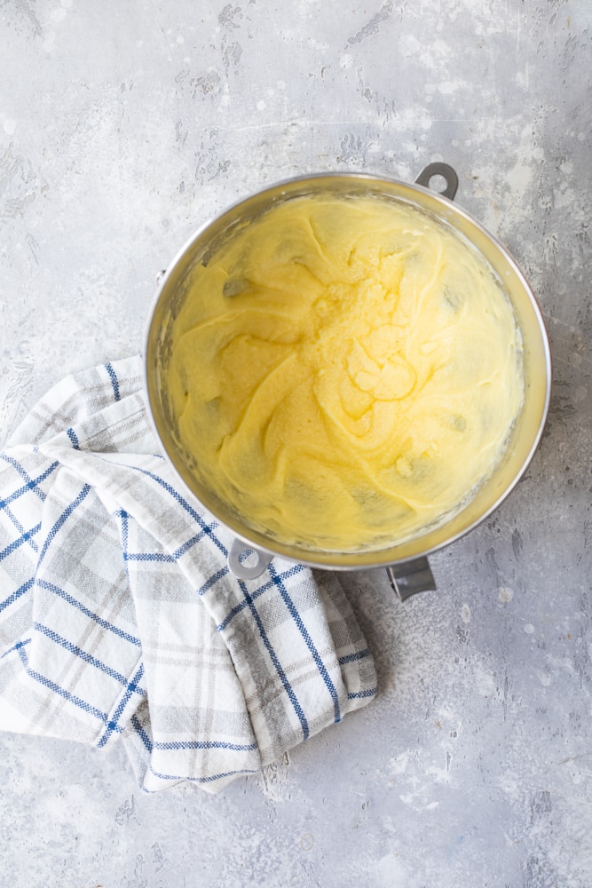 Overhead view of cake batter in mixing bowl with tea towel