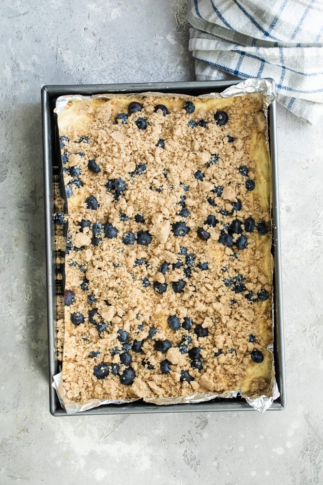 overhead view of Blueberry Crumb Cake batter topped with blueberries and crumb topping