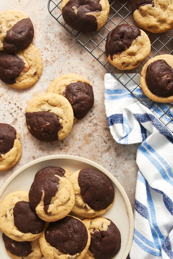 Chocolate Peanut Butter Swirl Cookies on a wire rack, a beige plate, and a light brown surface