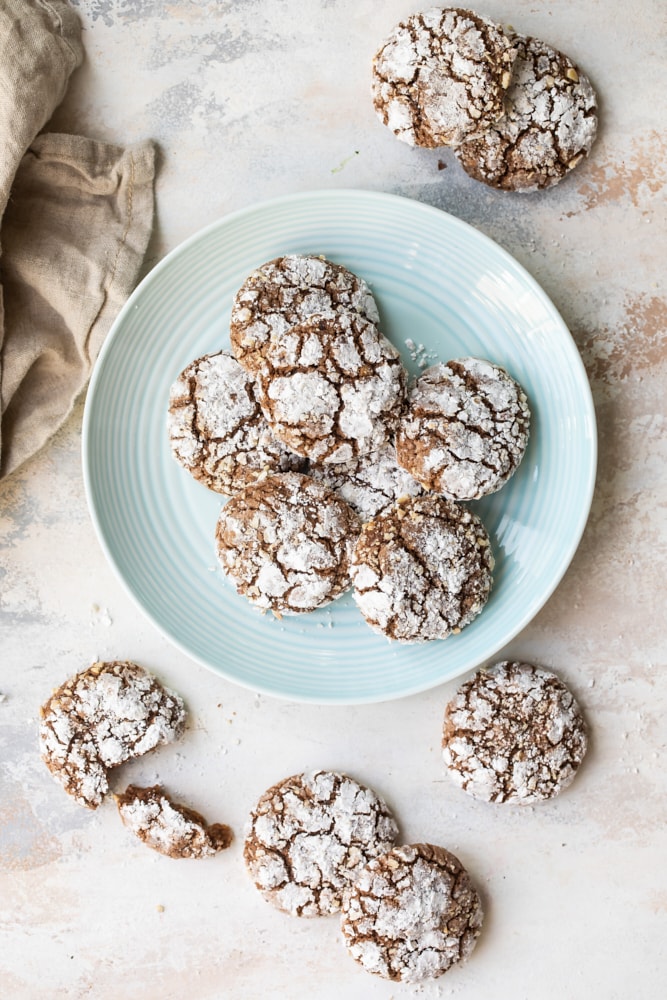 Overhead view of hazelnut crinkle cookies on a light blue plate.