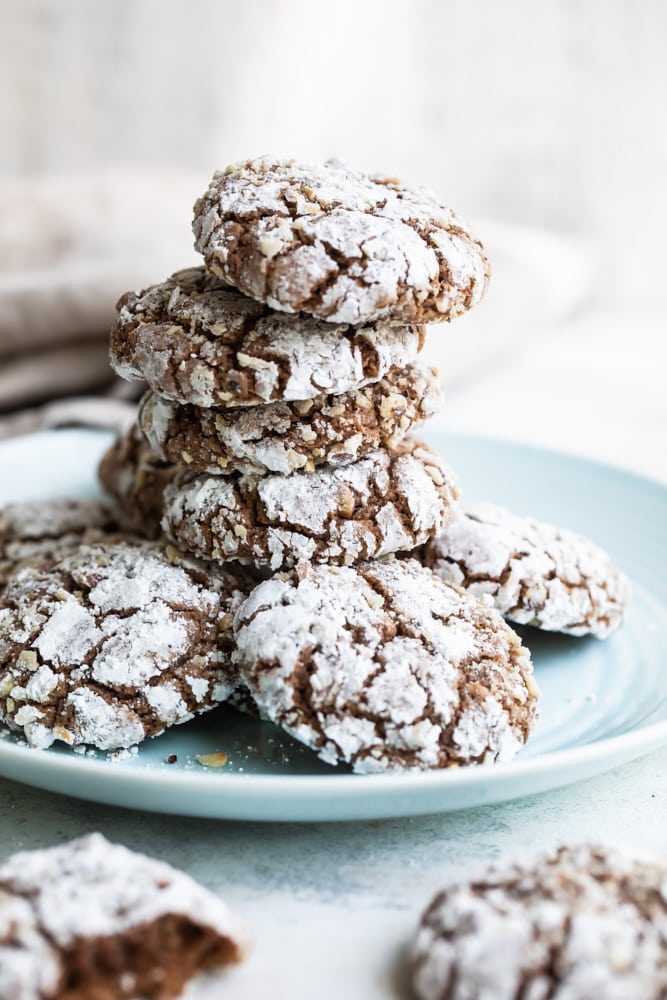 Hazelnut crinkle cookies stacked on a light blue plate.