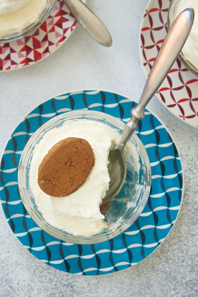 overhead view of No-Bake Lemon Cheesecake in a glass serving bowl on a colorful plate