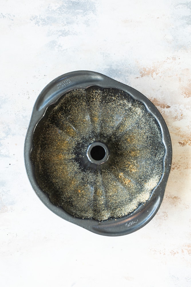 Overhead view of bundt cake pan greased and dusted with breadcrumbs