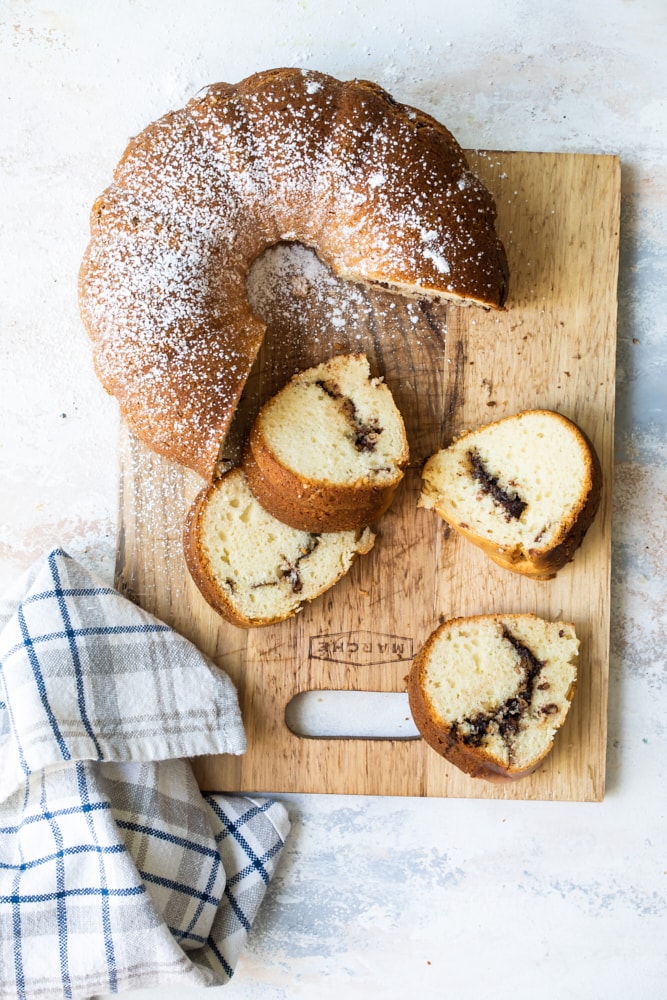 Overhead view of bundt cake on cutting board with four slices