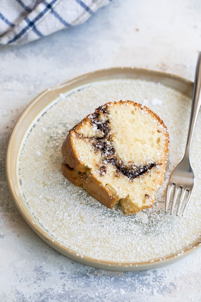 slice of Sour Cream Hazelnut Bundt Cake on a beige plate