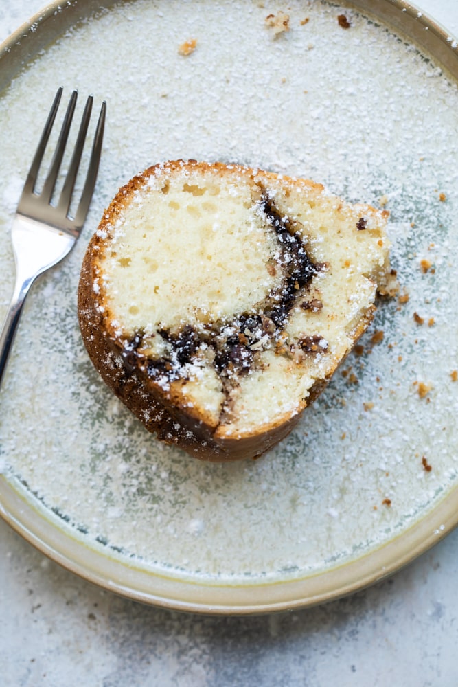 Overhead view of sour cream bundt cake with Nutella ribbon on plate with fork