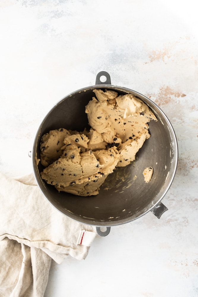 Overhead view of chocolate-dipped peanut butter meltaway cookie dough in a mixing bowl.