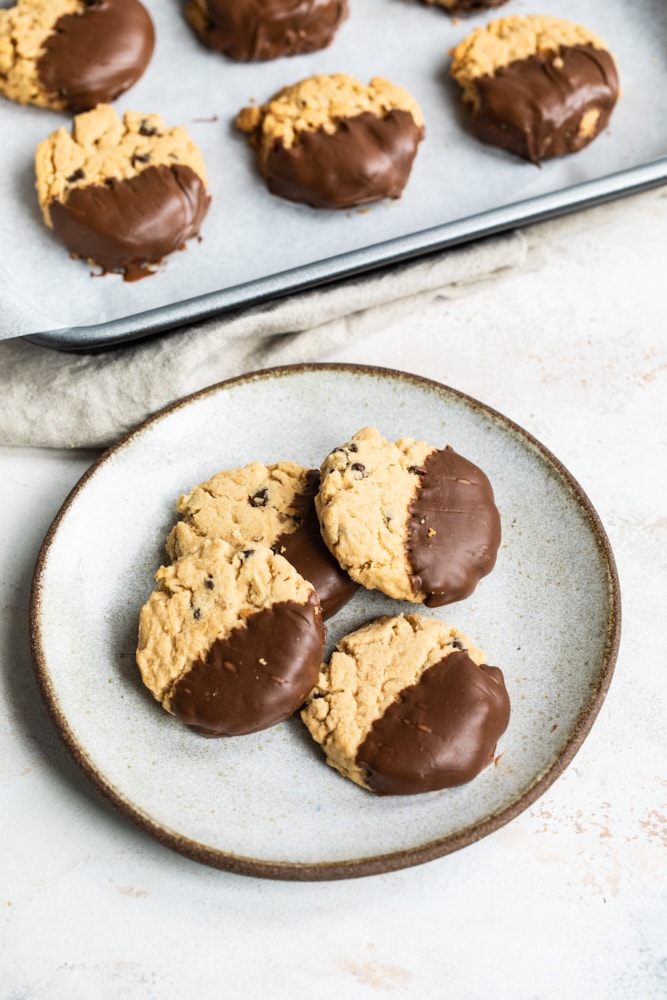 Peanut butter meltaway cookies dipped in chocolate on a plate.