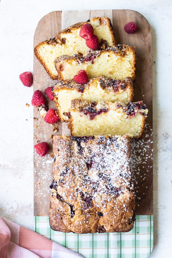 overhead view of Raspberry White Chocolate Almond Loaf on a wooden cutting board