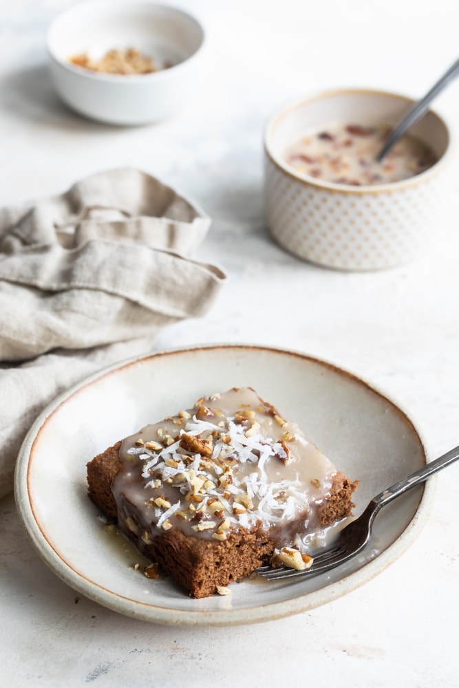 German chocolate cake with coconut flakes on a beige plate.