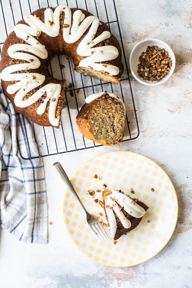 Overhead view of Hummingbird Bundt cake on plate with fork and on wire rack