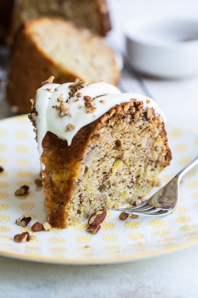 slice of Hummingbird Bundt Cake on a white and yellow plate