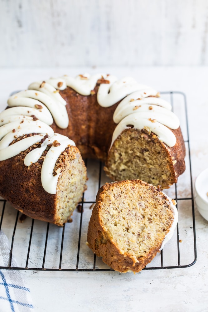 Hummingbird Bundt Cake on a wire rack with slice removed