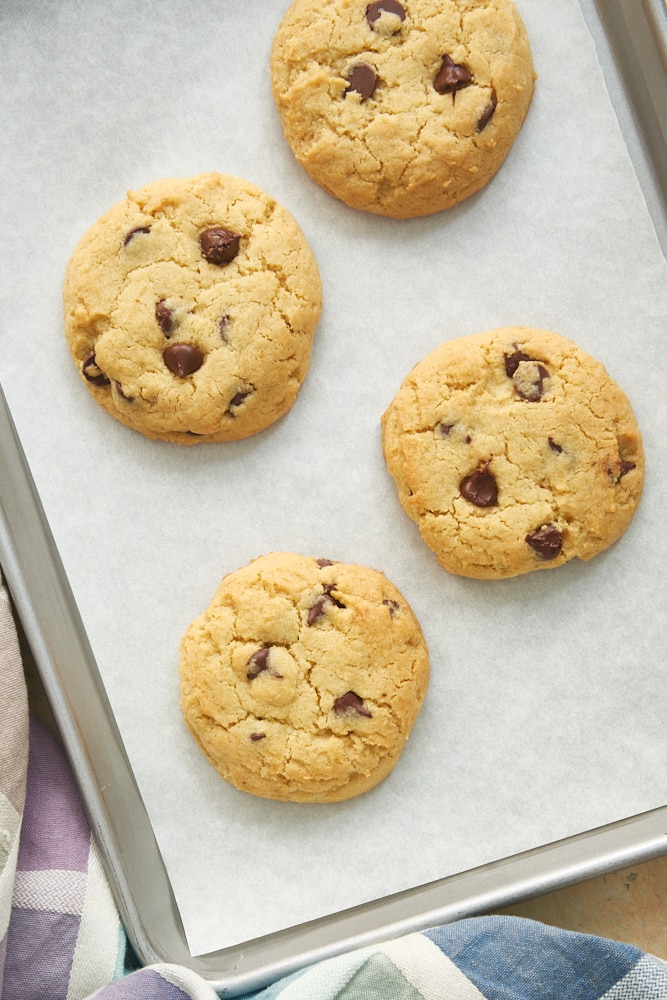 overhead view of chocolate chip cookies on a parchment-lined baking sheet