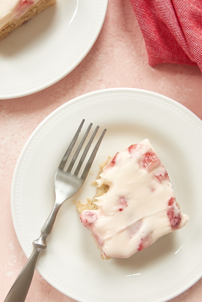 overhead view of a slice of strawberry cake with a bite missing