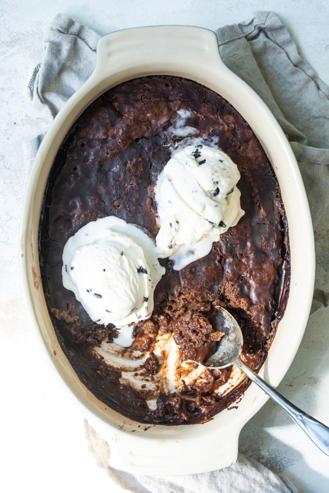 Brownie Chocolate Pudding Cake in baking dish with ice cream scoops on top