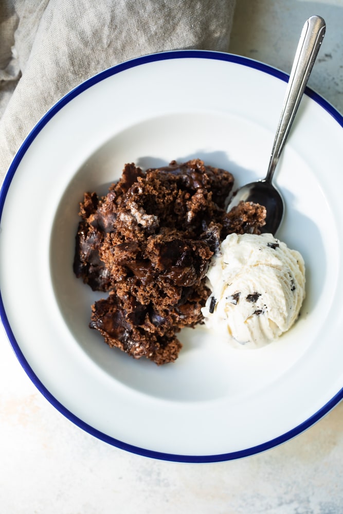 overhead view of Brownie Chocolate Pudding Cake in a blue-rimmed white bowl