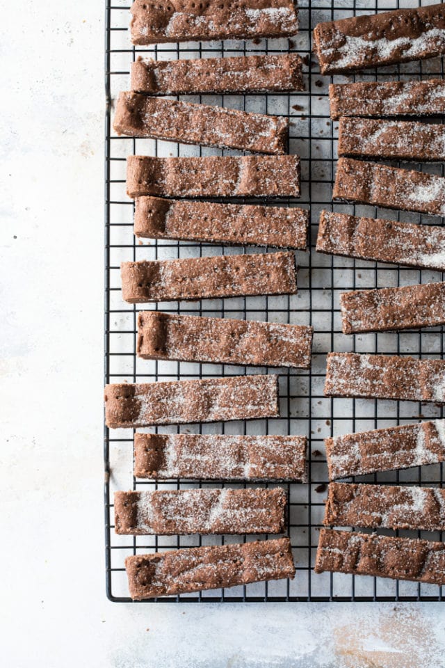 Overhead view of chocolate shortbread on a wire rack, dusted with sugar.