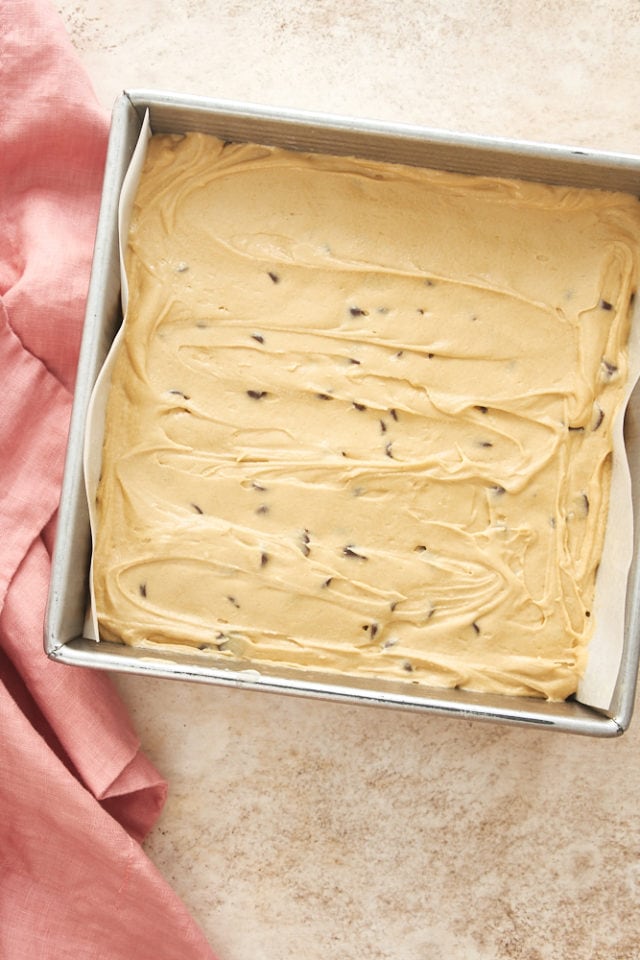 batter for Chocolate Chip Cookie Butter Snack Cake in a parchment-lined baking pan