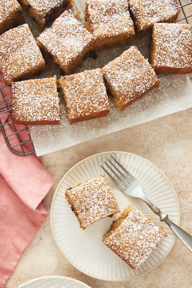 overhead view of Chocolate Chip Cookie Butter Snack Cake on a white and beige plate and on a wire rack