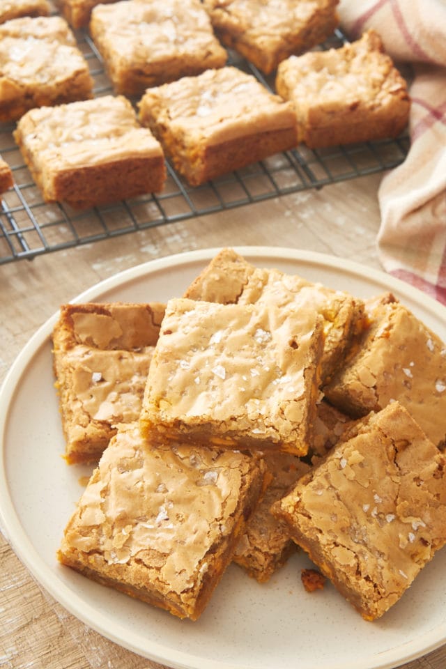 Salted Butterscotch Blondies piled on a beige plate