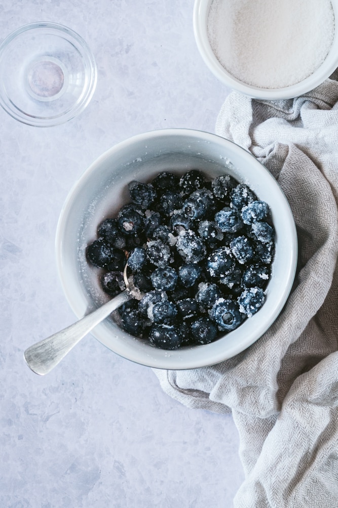 sweetened blueberries mixed with lemon juice in a white bowl