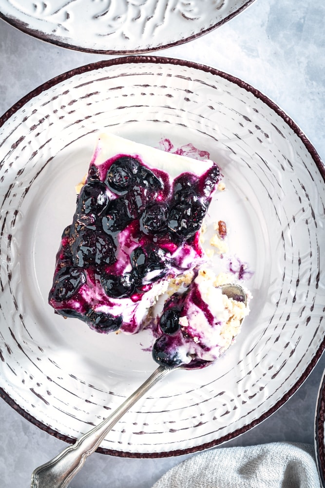 overhead view of a slice of Blueberry Jamboree on a white and gray plate