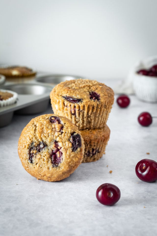 stack of Cherry Cheesecake Muffins on a gray surface