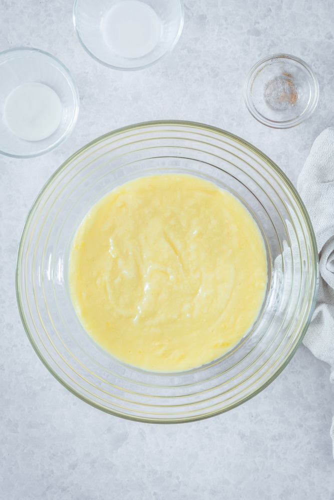 Overhead view of pastry cream in glass mixing bowl