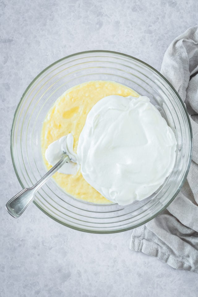Overhead view of pastry cream and whipped cream in glass bowl