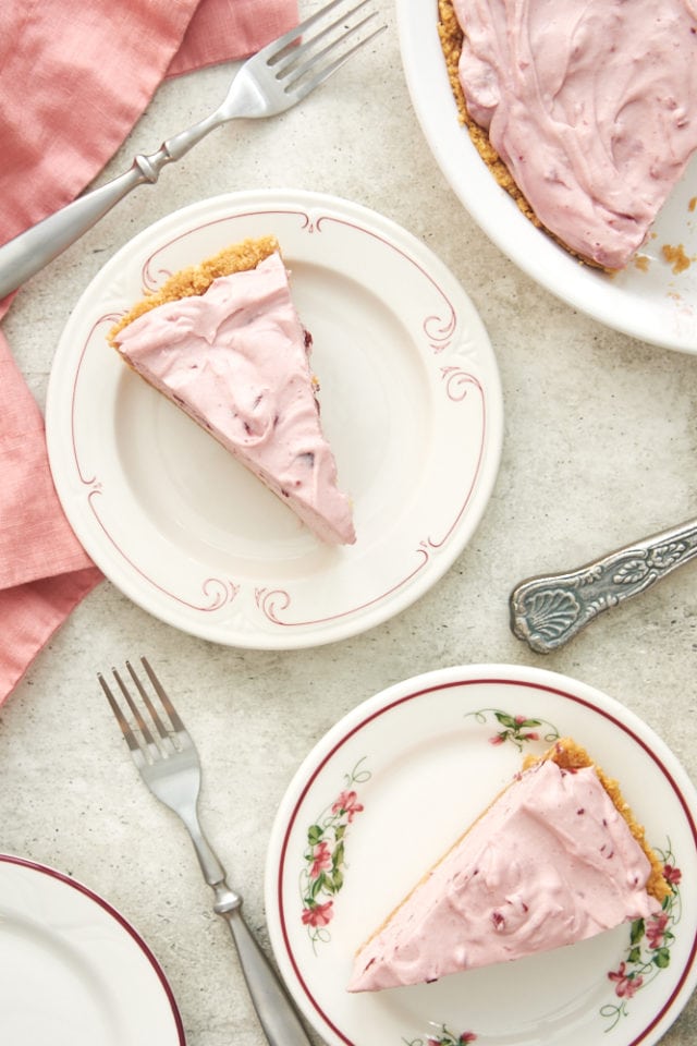 overhead view of slices of Cherry Vanilla No-Bake Pie on red-rimmed white plates