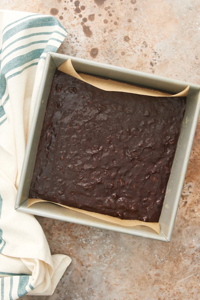 Double Chocolate Zucchini Brownie batter in a parchment-lined baking pan