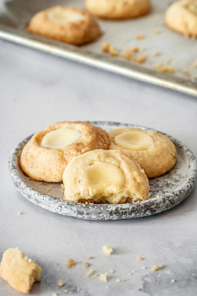three Cheesecake Thumbprint Cookies on a gray and white plate