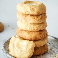 stack of Cheesecake Thumbprint Cookies on a gray and white plate