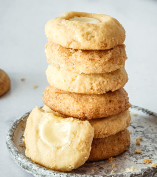 stack of Cheesecake Thumbprint Cookies on a gray and white plate