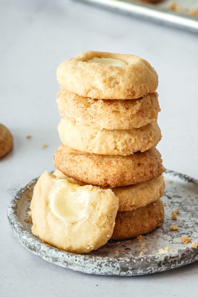 stack of Cheesecake Thumbprint Cookies on a gray and white plate