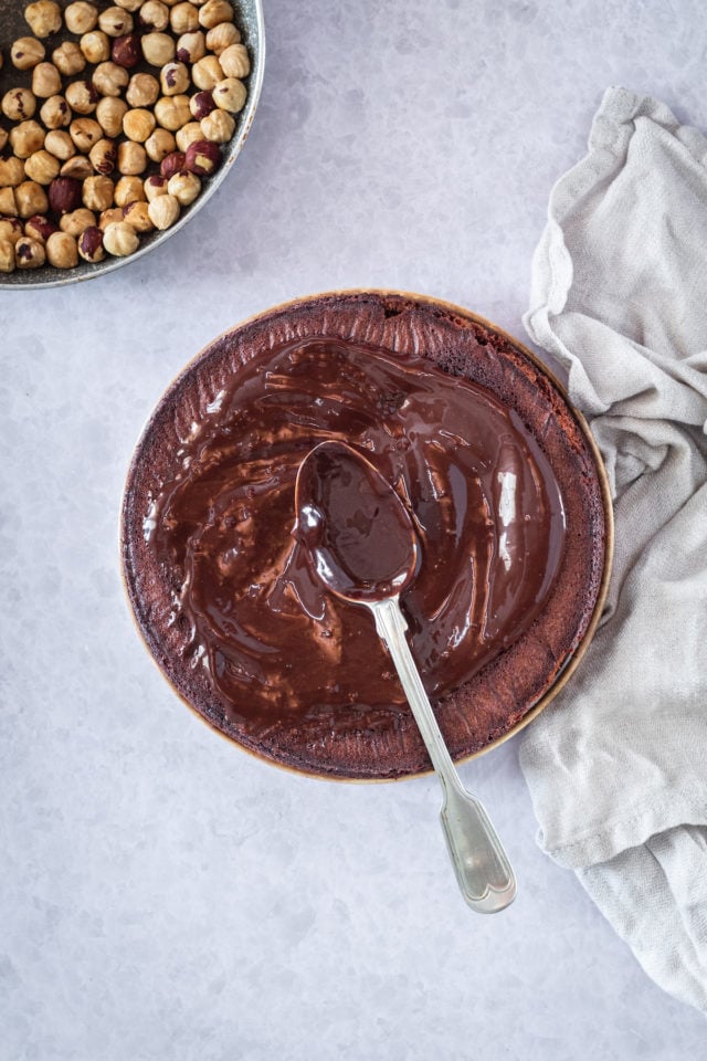 frosting a chocoalte cake with a spoon