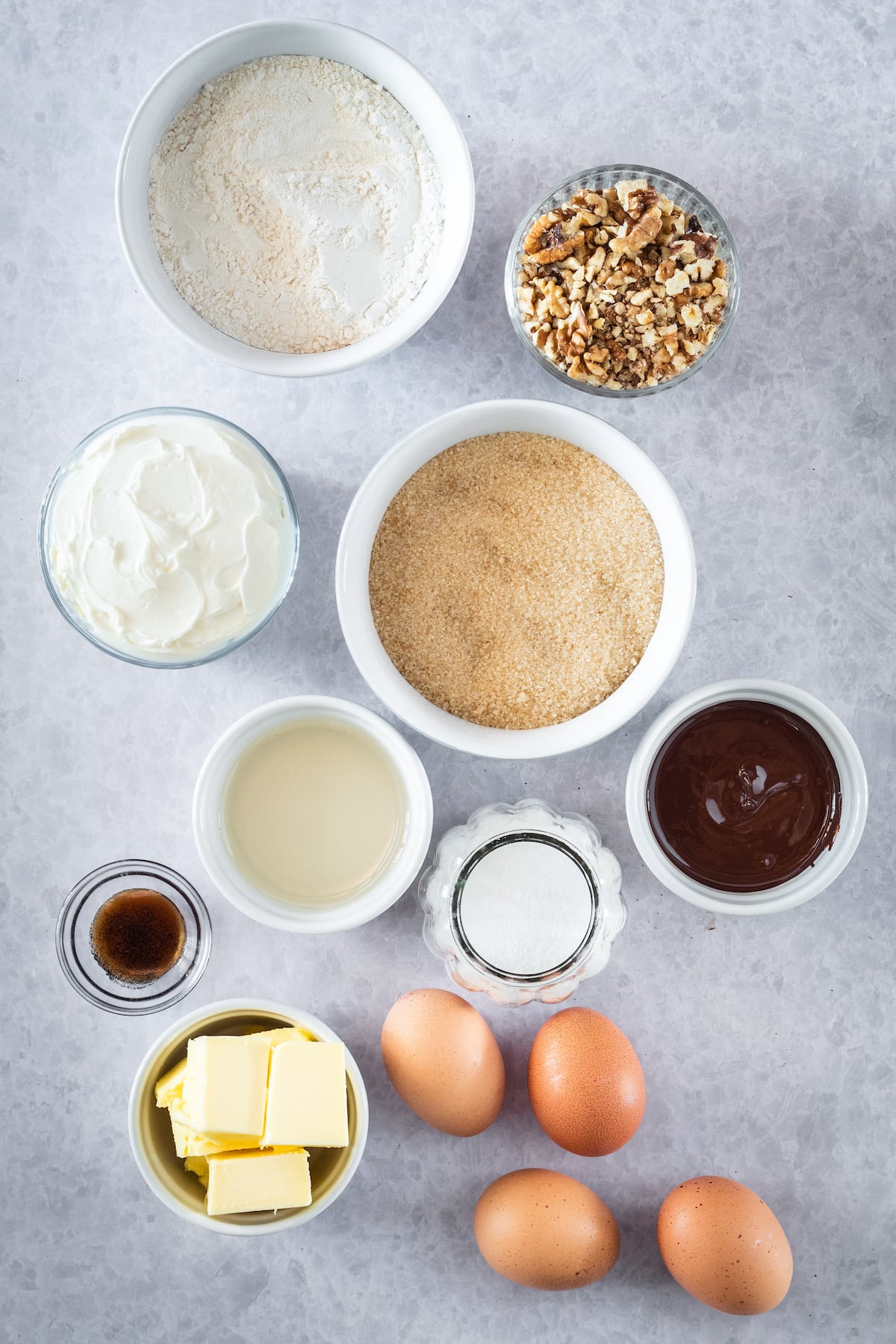 ingredients in small bowl for baking: eggs, flour, chocolate and pecans