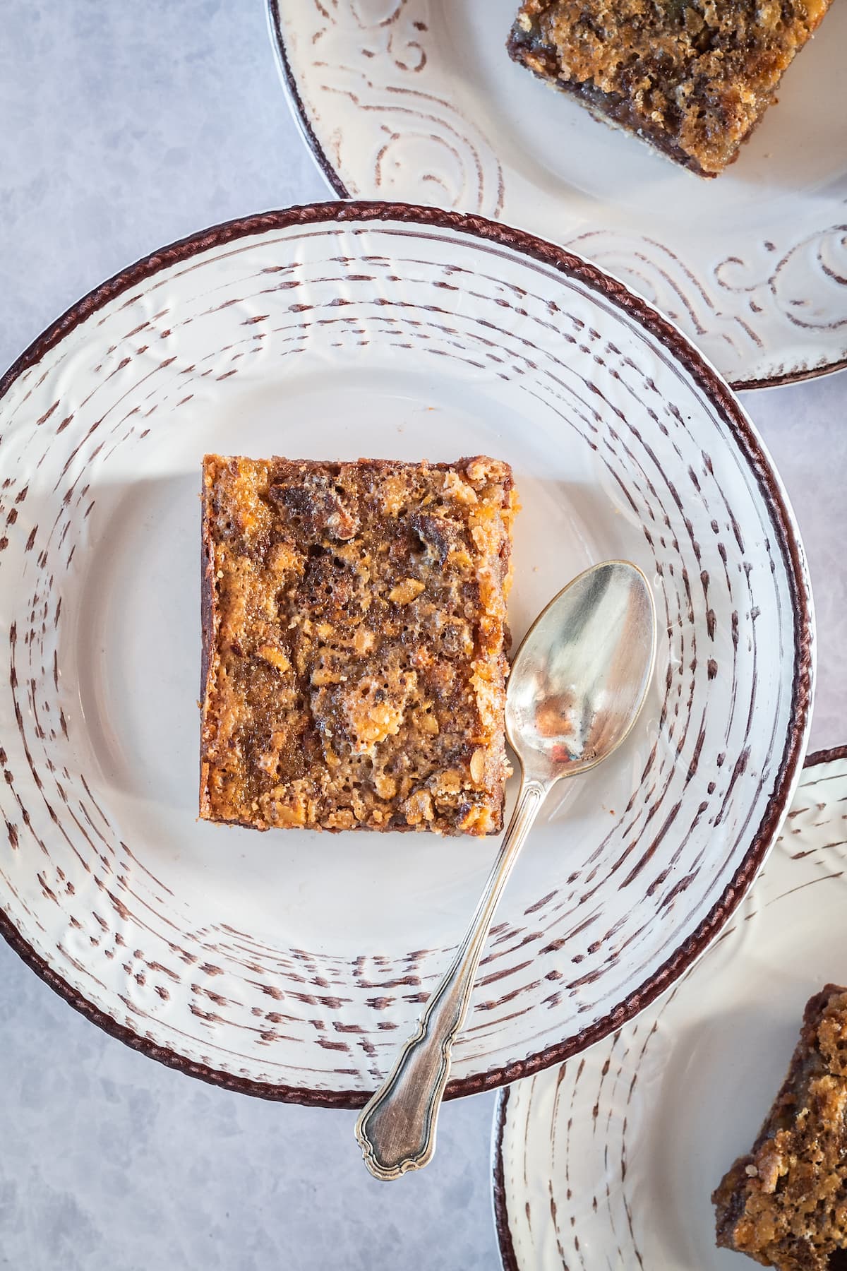 overhead of a cheesecake bar with pecans on a plate with a spoon