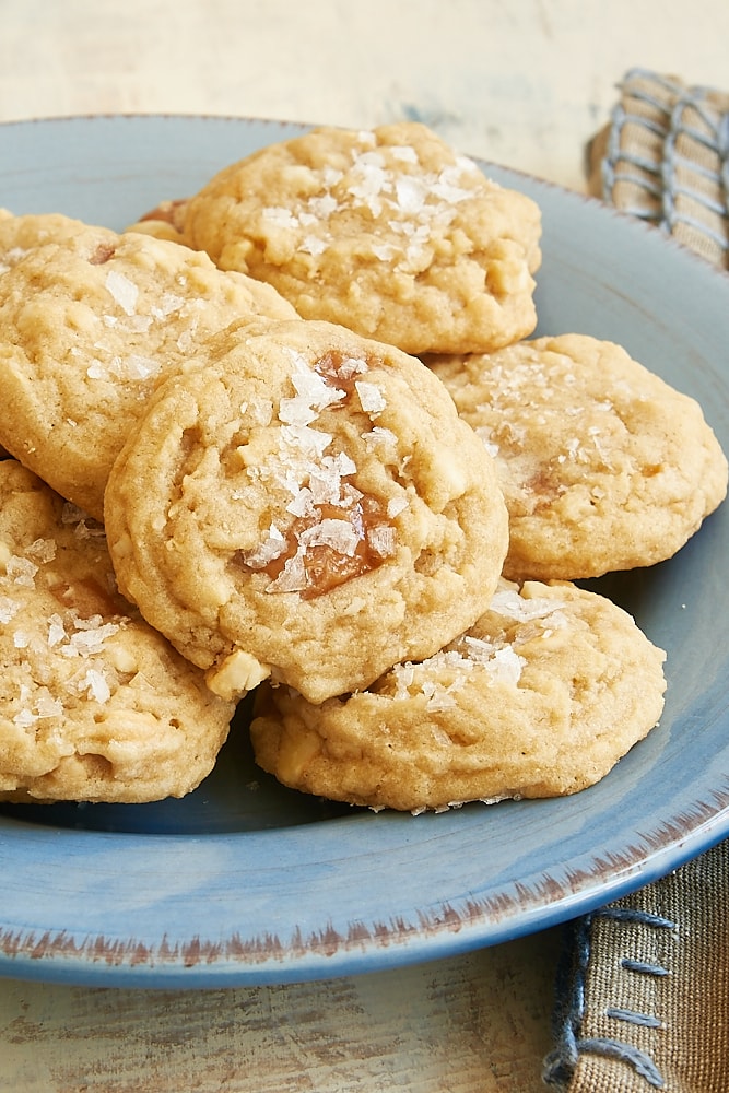 pile of Salty Cashew Caramel Cookies on a blue plate
