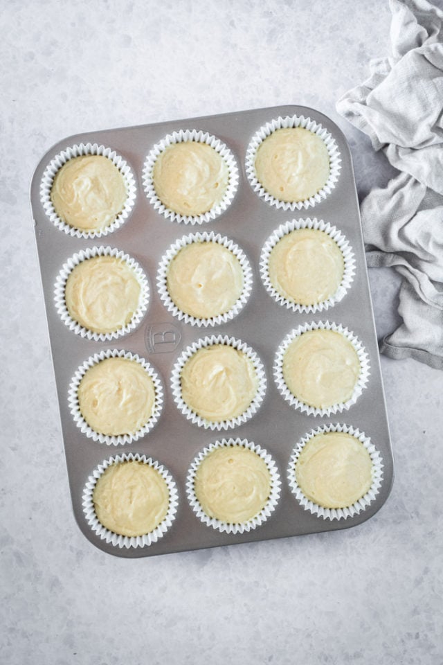 overhead view of muffin batter portioned into a lined muffin pan