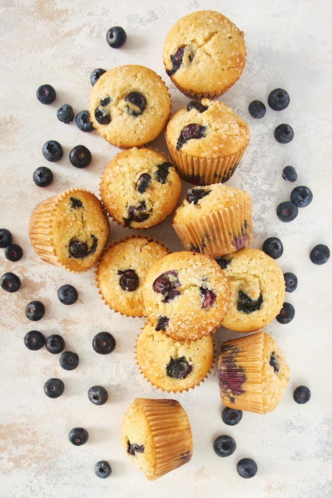 Overhead view of Pineapple Blueberry Muffins on a beige surface.