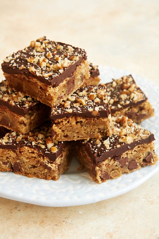 Chocolate Chip Ganache Blondies piled on a light blue and white plate