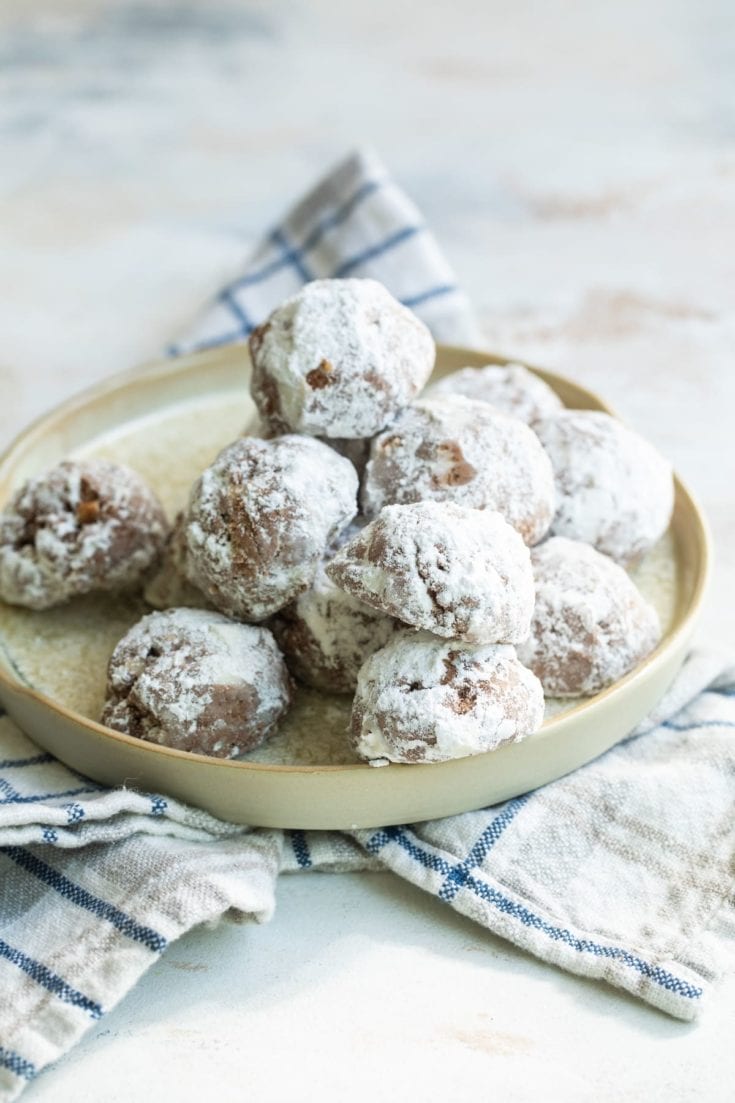 plate of powdered sugar-dusted coco macadamia nut cookies