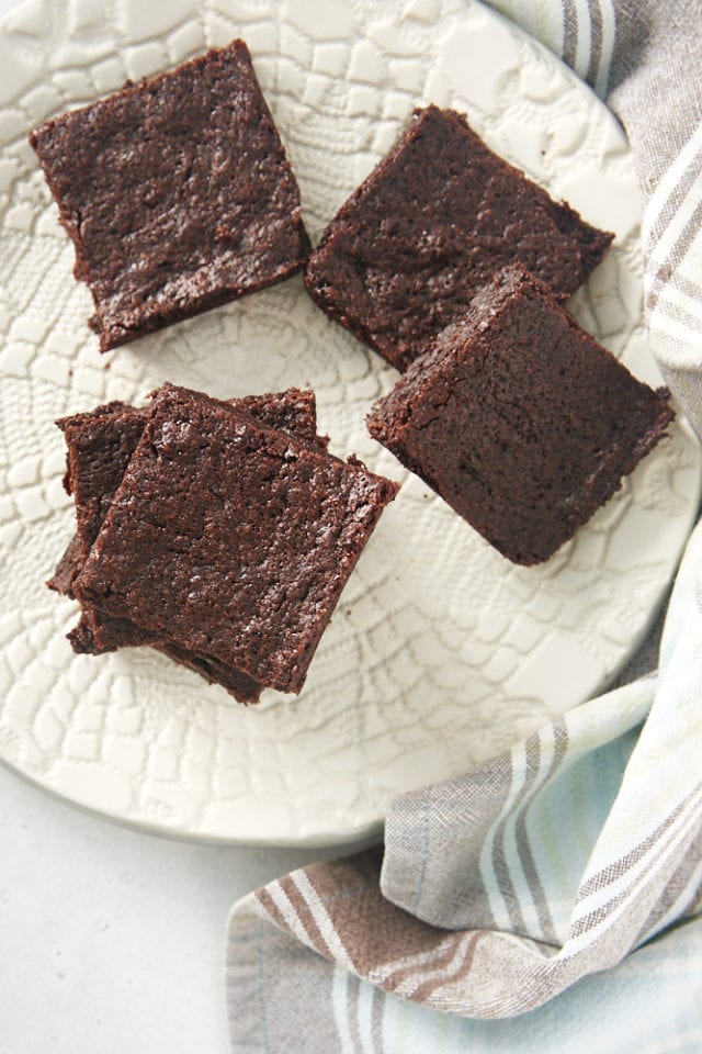 overhead view of brownies stacked on a white plate